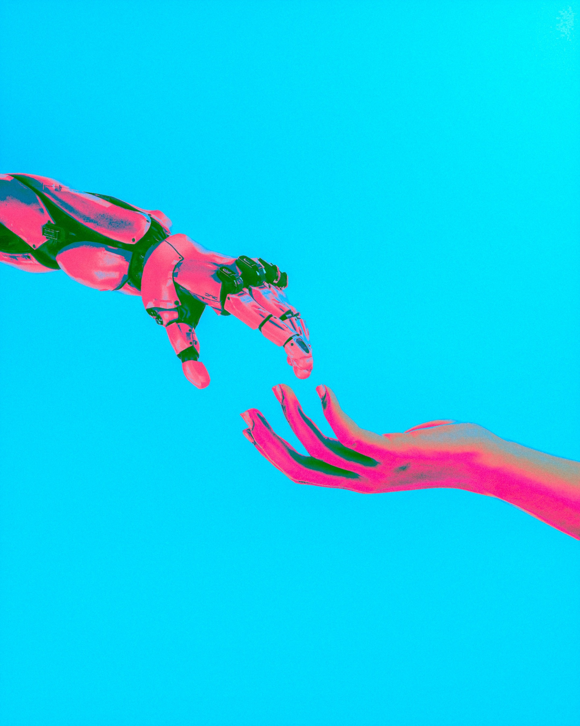 A human hand reaching toward a robotic hand against a cyan background.